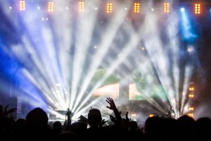 Vibrant nightclub concert with cheering crowd and dazzling spotlights.